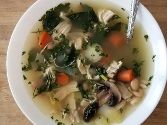 White bowl with soup on table