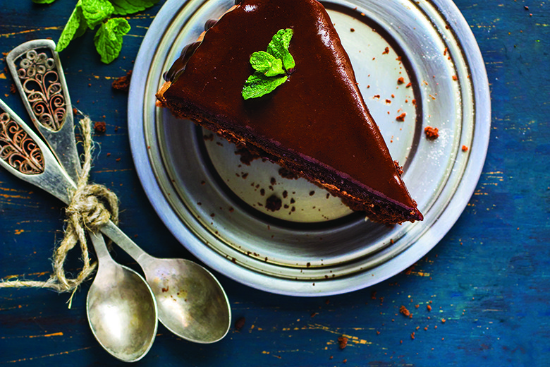 Mastering Vegan Baking | Food & Nutrition | November-December 2017 Piece of chocolate cake with mint leaves