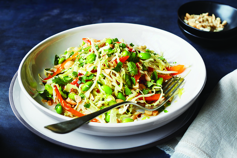 Spicy Edamame Slaw with Orange Dressing | Food & Nutrition | January February 2018 edamame slaw in white bowl with fork