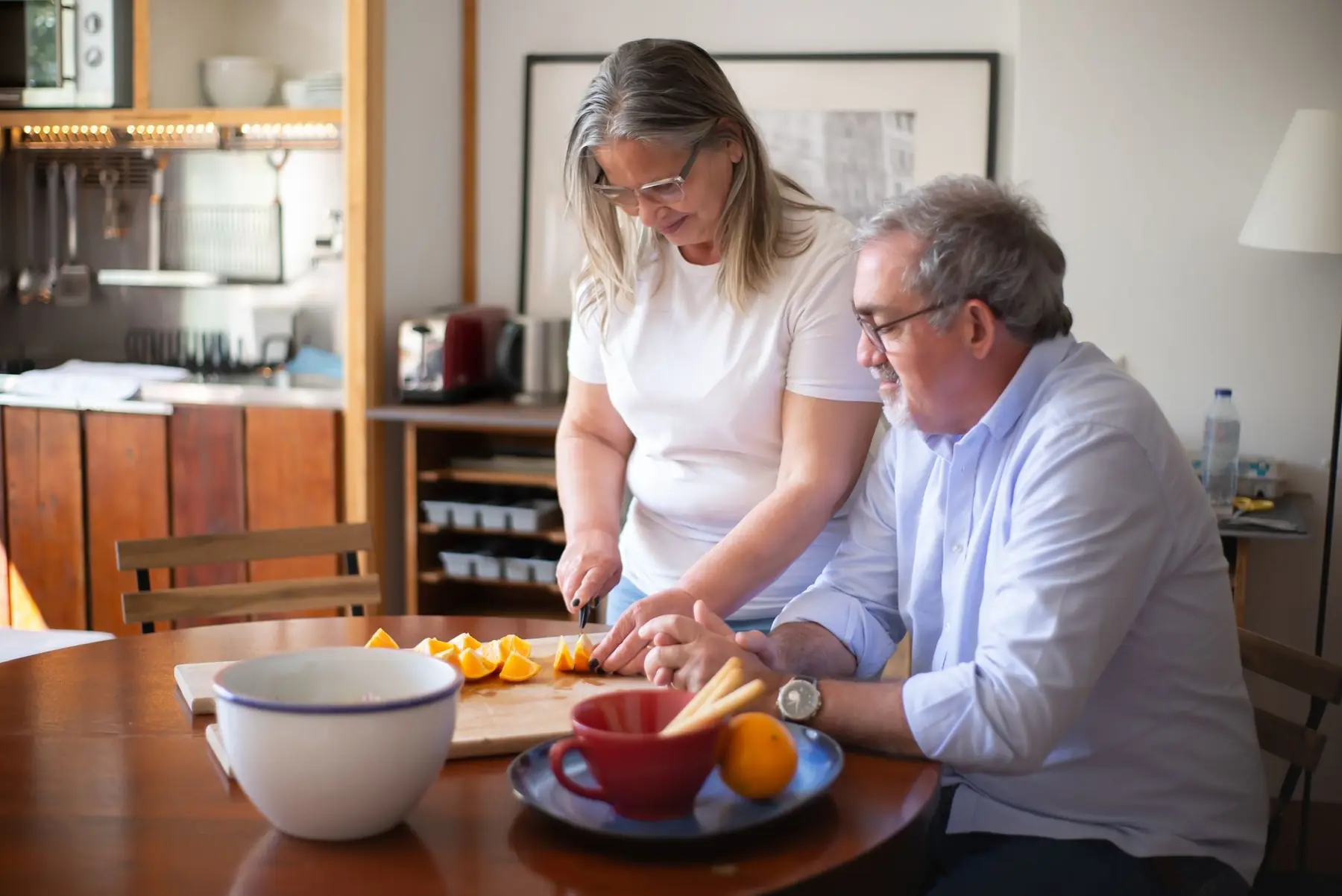 A couple enjoying preparing fresh oranges together in their cozy home kitchen setup