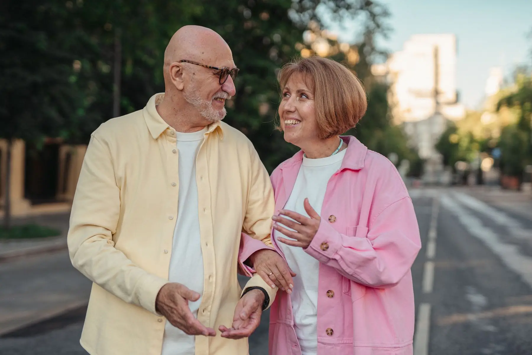 Happy senior couple walking hand in hand, sharing a joyful moment outdoors in a